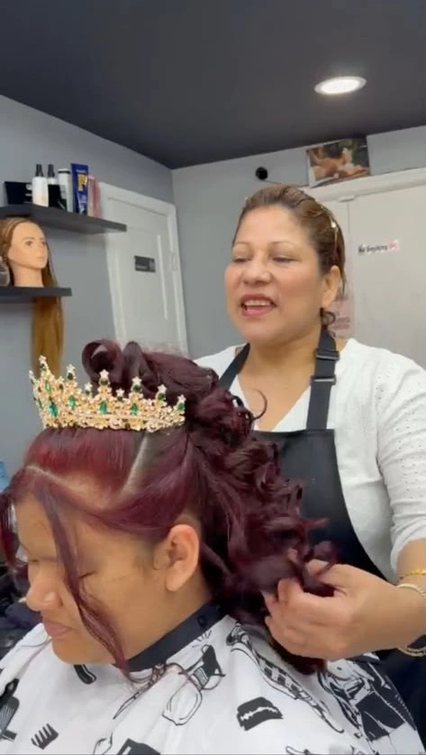 A New Style stylist finishing burgundy curls and a tiara for a special occasion